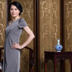 Elegancka mama pana młodego w szarej sukience, idealna na ślub. Klasyczna stylizacja, która podkreśla jej urodę.