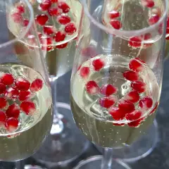 Szklanki z musującym napojem i nasionami granatu, idealne na drink bar na wesele.