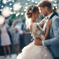 Para młoda tańczy przy blasku światełek, a w tle goście weselni. Idealne piosenki na wesele podkreślają ten magiczny moment.