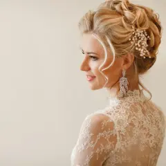 Elegancka fryzura na wesele: upięcie z perłami i długimi kolczykami. Idealna inspiracja dla panny młodej.