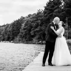 Para młoda całuje się na pomoście. Zastanawiasz się, ile kosztuje fotograf na wesele? Taka chwila warta jest uwiecznienia.