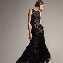 Modelka w czarnej, koronkowej sukni z falbanami, idealnej na black tie dress code damski.