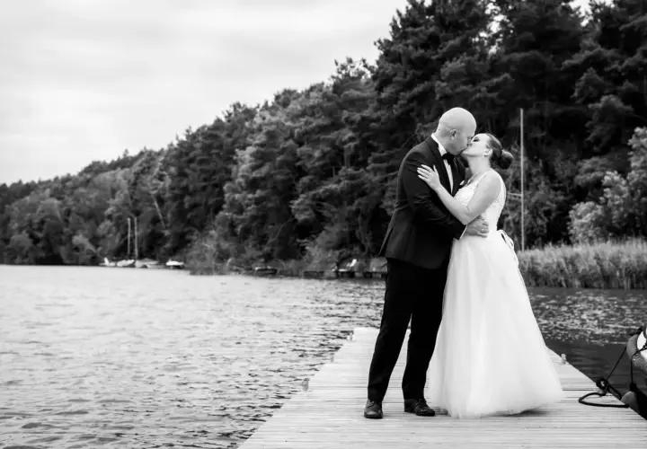 Para młoda całuje się na pomoście. Zastanawiasz się, ile kosztuje fotograf na wesele? Taka chwila warta jest uwiecznienia.