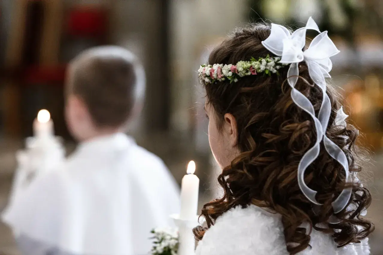Dziewczynka z wiankiem i wstążkami we włosach trzyma świecę. Obok niej chłopiec. To ważny dzień, zastanawiasz się, ile trwa biały tydzień?